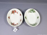 Two oval serving bowls side by side, showing floral patterns of both dishes and gold rims.