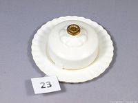 Butter dish set photographed with lid on underplate showing overall shape, gold trim and knob.