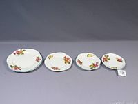 Four Shelley Begonia dainty shape plates arranged by size, showing floral decoration and condition.