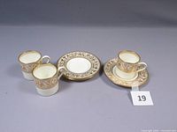 Three Wedgwood Gold Florentine demitasse cups and three matching saucers, showing overall set composition