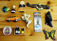 Full set of 11 assorted decorative fridge magnets displayed on wooden surface