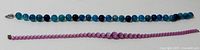 Overview photo of two bead necklaces laying flat showing colors and bead sizes.