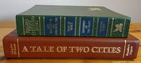 Close-up of spines showing titles of four Agatha Christie novels in green box and browned book 'A Tale of Two Cities'