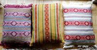 Three hand embroidered Estonian pillows arranged side by side showing color and pattern variety