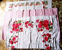 Three tablecloths laid out folded and overlapping showing floral and checkered patterns