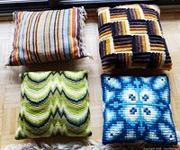 Four handmade cushions displayed together showing different colors and patterns.