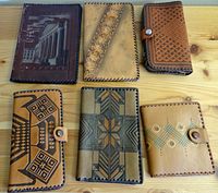 Overview of six leather wallets and covers showing front embossed and printed designs