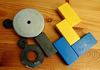 Magnets arranged on wooden surface showing front side variety