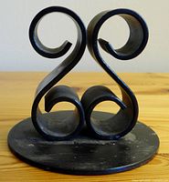 Front view showing the scroll design and circular flat base.