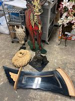 Giraffe mask, lion head stone sculpture, man head sculpture, bull resin sculpture, and mirror seen from a distance on floor