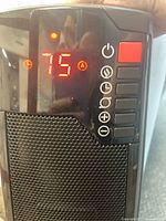 Close-up of the heater's digital control panel showing LED display with temperature setting and control buttons including power and heat settings.