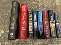 Photo of the spines of 8 suspense and thriller books by Sandra Brown and Lisa Jackson showing titles and authors.