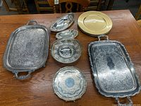 All nine items on wood table showing shapes, sizes, and decorative etched patterns