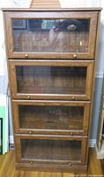 Front view of four-tier barrister bookcase showing glass-front compartments