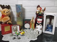 Full lot view showing plush reindeer, Lenox snowman, crystal bowl, nativity figure, musical bell recorder in box and assorted small Christmas decorations.