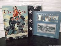 Two hard cover Civil War history books and an American flag folded nearby.