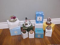 Photo showing 8 different vintage candle toppers placed on and around original boxes, visual condition like new