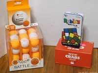 Photo showing Bounce Battle balls and cards, You've Got Crabs and Rubik's Battle games stacked