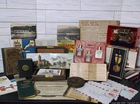 Full view of assorted lot contents including letters, postcards, catechism book, ephemera, miniature coach, medal, and various papers.