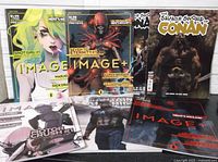 Seven Image Comics oversized comic books arranged in two rows showing their covers including Snotgirl #1, Seven to Eternity #1, The Savage Sword of Conan and others.