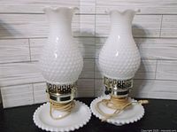 Pair of white milk glass hobnail lamps side-by-side showing their shape, base, and scalloped shades.