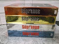 Four DVD box sets of The Sopranos stacked horizontally showing titles for seasons 2 through 5.