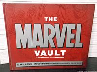 Front red hardcover of The Marvel Vault book with large silver and white title text