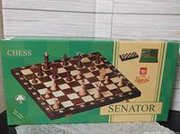 Box displaying the chess set brand 'Senator' and an image of the chessboard with pieces arranged on it.