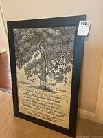 Framed black and white vintage poster with a tree illustration and song lyrics, visible overall lot view.