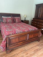 Full front view of assembled bed frame with red paisley bedding