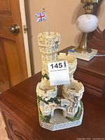 Front view of the detailed castle tower sculpture with British flag and original labeling visible.