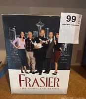 Front cover photo of Frasier complete series DVD box, showing main cast standing in front of the Seattle skyline with the Space Needle.