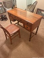 Full view of the vintage solid wood desk and matching chair placed together showing overall condition and design.