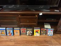 Media center showing Sony Blu-Ray/DVD player on wooden cabinet, with DVDs and Blu-Ray discs displayed in front.