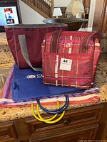 Two insulated tote bags on kitchen counter: maroon Texas A&M bag and smaller plaid Igloo bag