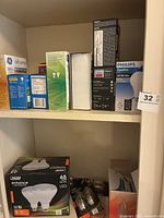 Shelf with various boxed light bulbs including GE, Philips, and Cree.