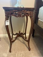 Full view of the vintage wooden French side table showing carved details and overall structure.