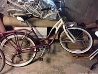 Maroon and cream Schwinn step-through bicycle with fenders and rear rack, visible wear, and dust