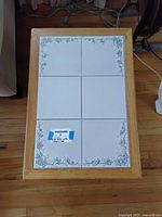 Top view of the end table showing six ceramic tiles with white background and blue floral border pattern on four tiles.
