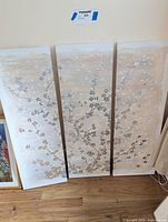 Three vertical canvas panels arranged side by side featuring beige and brown abstract floral branches on a light background.