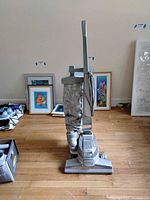 Front view of Kirby upright vacuum cleaner with cloth dust bag on hardwood floor.