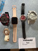 Overview of all five watches laid out flat on grey surface