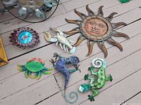Overview of multiple decorative garden art pieces including sun faces, crab, lobster, seahorse, and lizard.