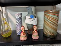 Shelf display showing 6 items: 4 vases and 2 figurines with pink and red accents, various glass and ceramic materials, medium size range
