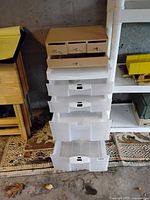 Close-up of stackable plastic storage drawers with small wooden drawer organizer on top