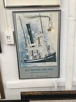 Framed BC Binning Heffel Gallery poster on wall, showing full view including aluminum frame, light switch to left.