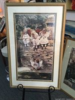 Full view of the framed print showing four angelic children on a stone wall and baby angel on the grass.