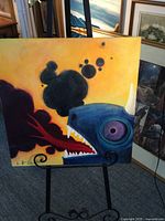 Front view of the whimsical dragon painting on easel showing the dragon's head, fire, and smoke.