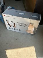 Box front showing the product image and branding, indicating the product is a Shiatsu massage seat cover for neck and back by DeLuxe Health & Wellness.