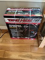 Box showing the front of Dino-Hide retractable air hose reel packaging with key specifications like 50 ft hose length and 300 PSI working pressure